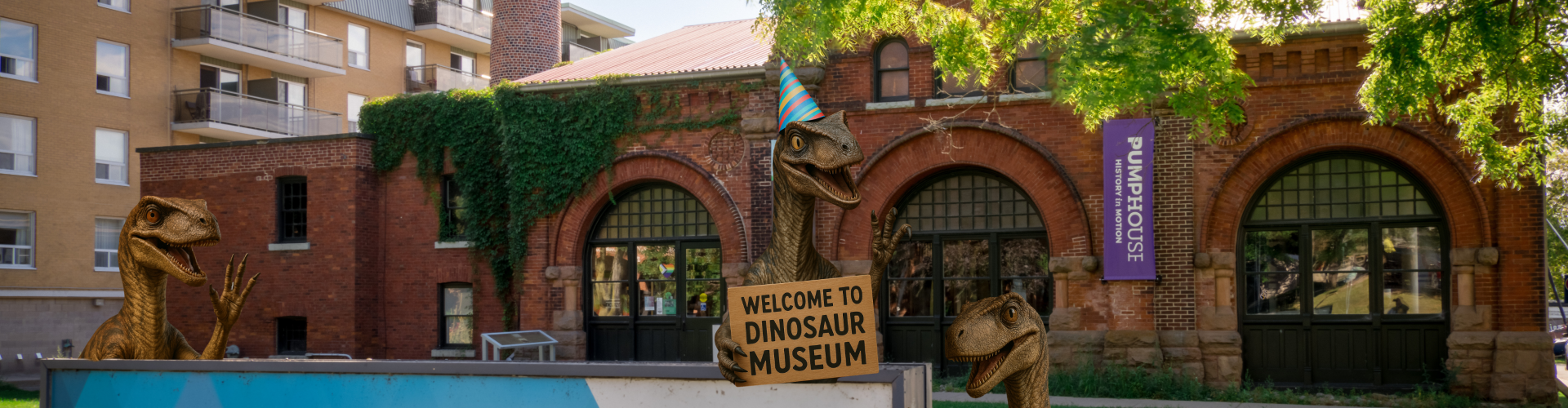 PumpHouse Museum building front, with dinosaurs waving having changed the sign to read "Dinosaur museum"